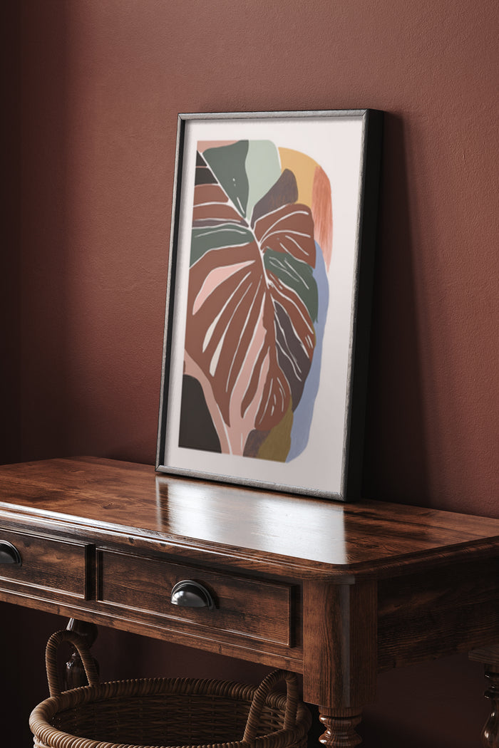 Contemporary abstract monstera leaf artwork in a modern frame on a wooden console table