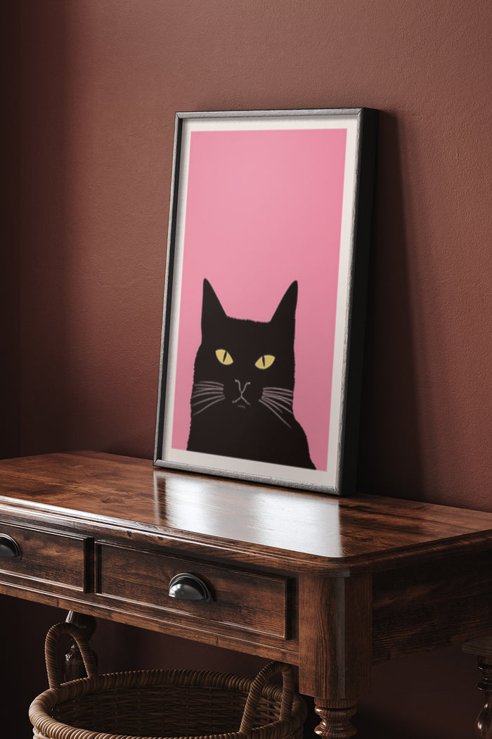 Modern black cat artwork poster against pink background on wooden console table