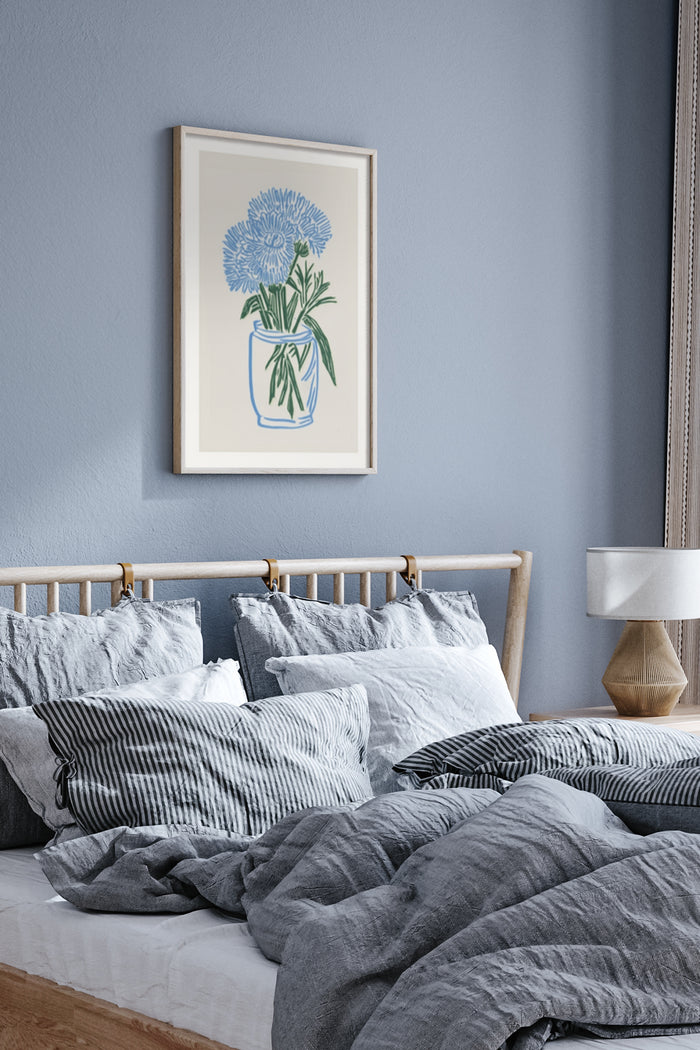Stylish blue flower poster framed on bedroom wall above cozy bed with gray linens