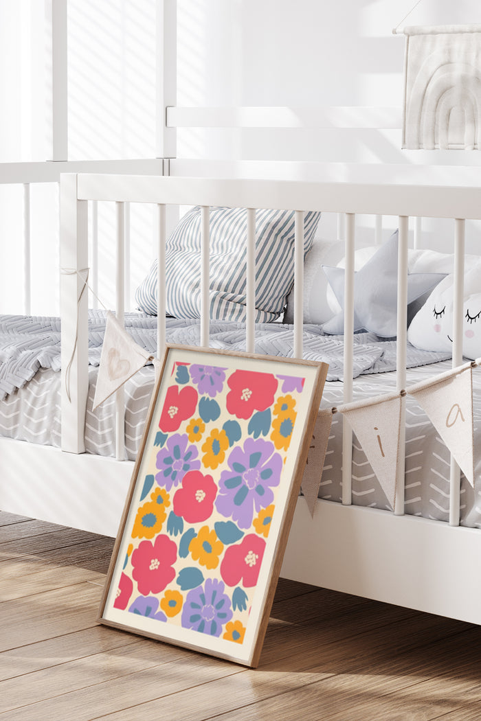 Bright and colorful floral poster leaning against a white crib in a modern nursery room setting