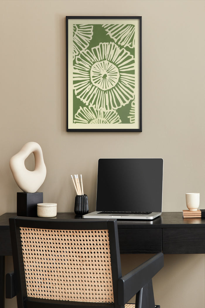 Stylish green and white floral poster design on a beige wall above a modern desk with laptop, decorative sculpture, and stationery holder