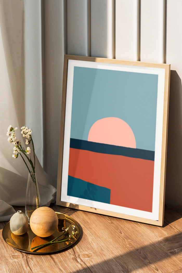 Minimalistic framed sunset poster against a curtain backdrop with decorative items