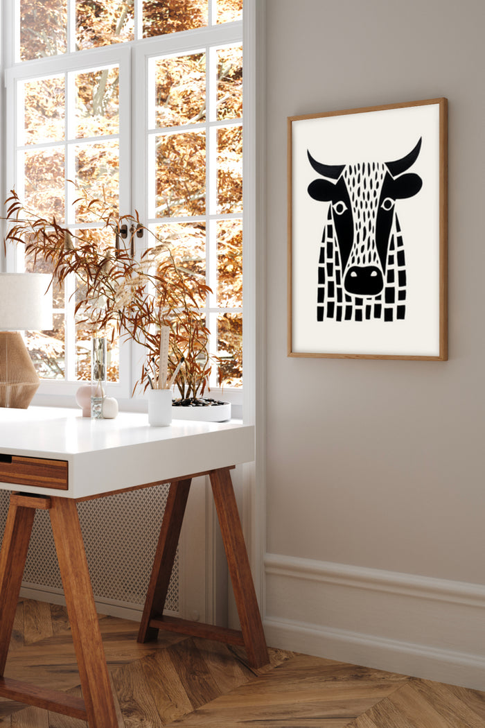 Modern black and white cow artwork poster framed on a wall in a stylish room with autumn view outside