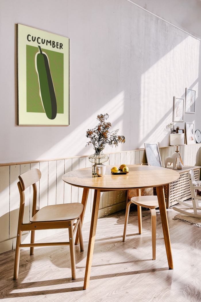 Stylish interior with modern cucumber poster artwork on the wall, wooden table and chairs with natural sunlight
