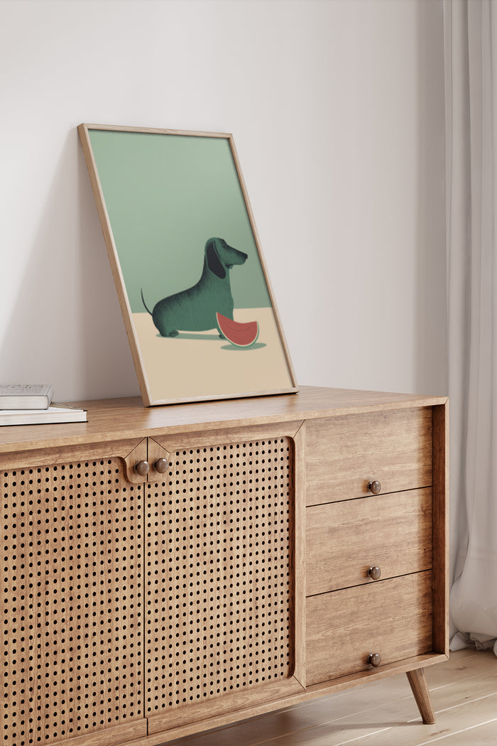 Modern minimalist dachshund dog art poster with a slice of watermelon placed in a wooden frame on a mid-century sideboard