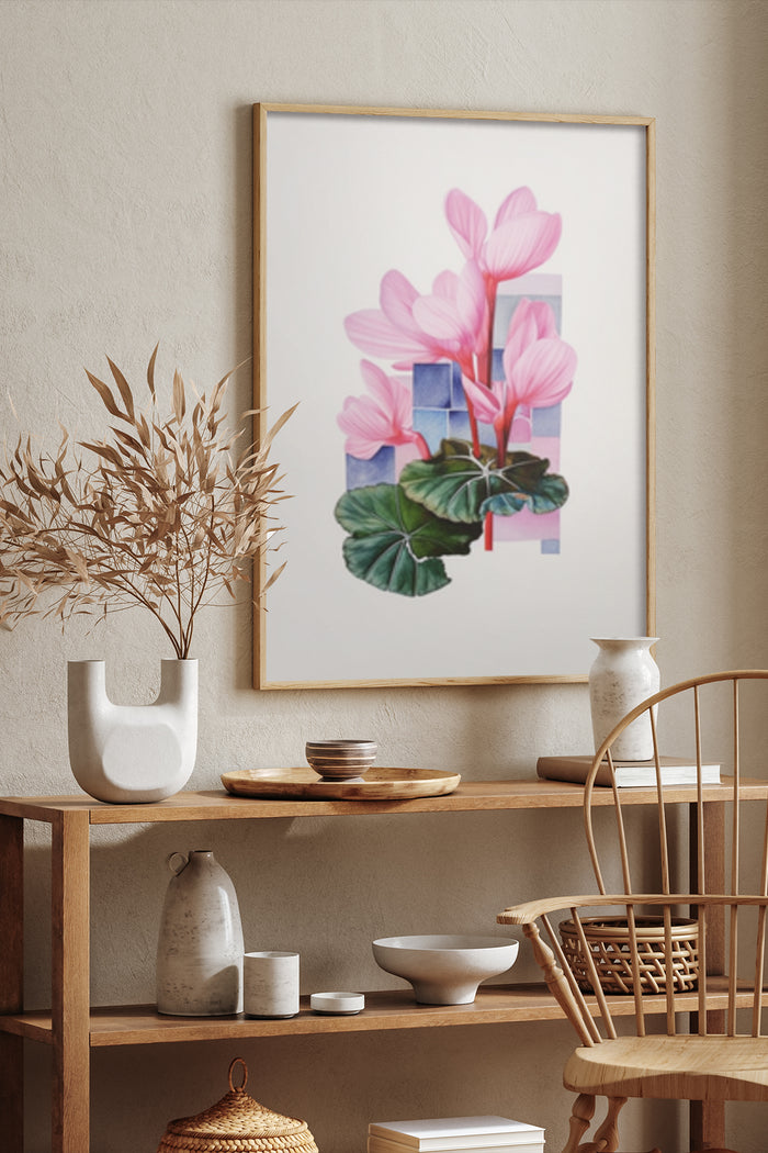 Contemporary pink flowers and geometric shapes poster framed on wall above wooden shelf with decorative items in a modern interior design layout