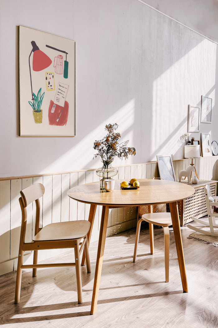 Stylish dining room interior with modern abstract art poster on the wall, wooden table and chairs, and decorative vase with flowers