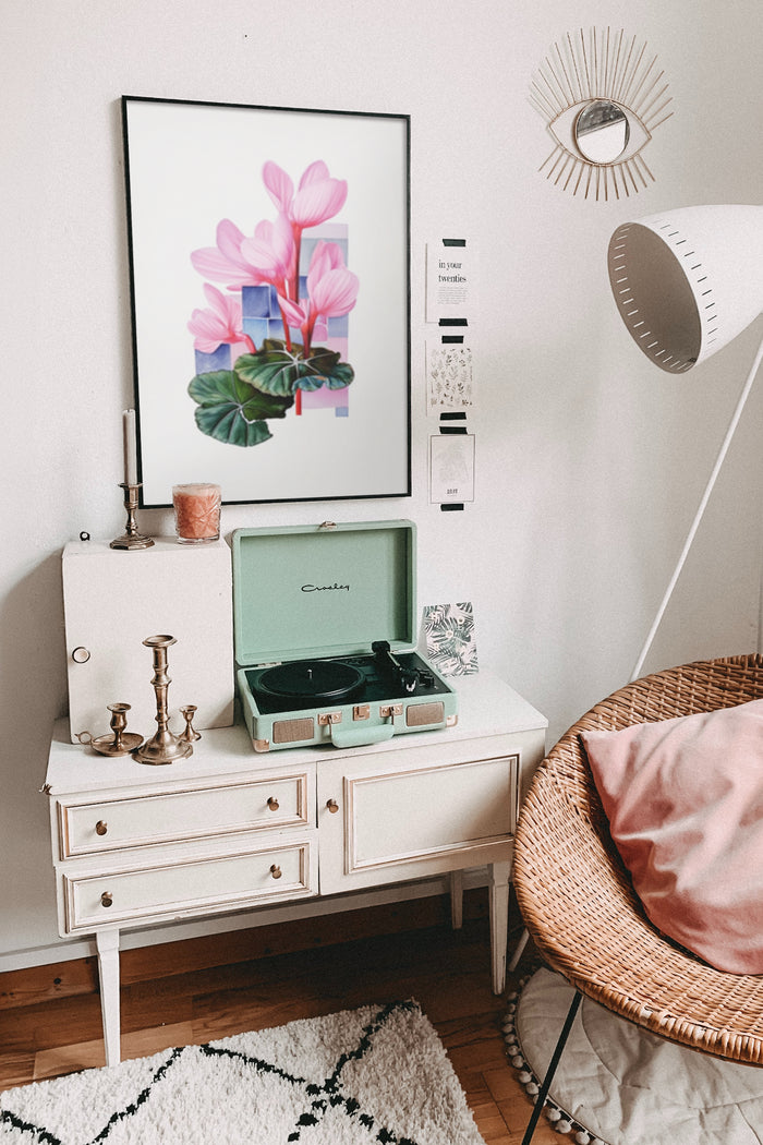 Stylish interior design with modern pink flower poster artwork, vintage record player, and chic home decor