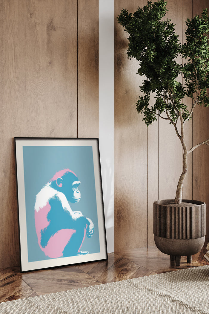 Contemporary pop art style monkey poster framed on wooden floor beside potted tree