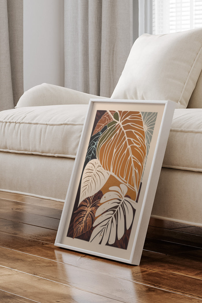 Stylish tropical leaf design poster framed and leaning against a wall in a modern home setting
