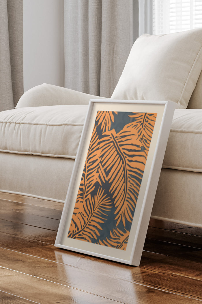 Contemporary tropical leaf design poster framed and leaning against wall in a stylish living room setting