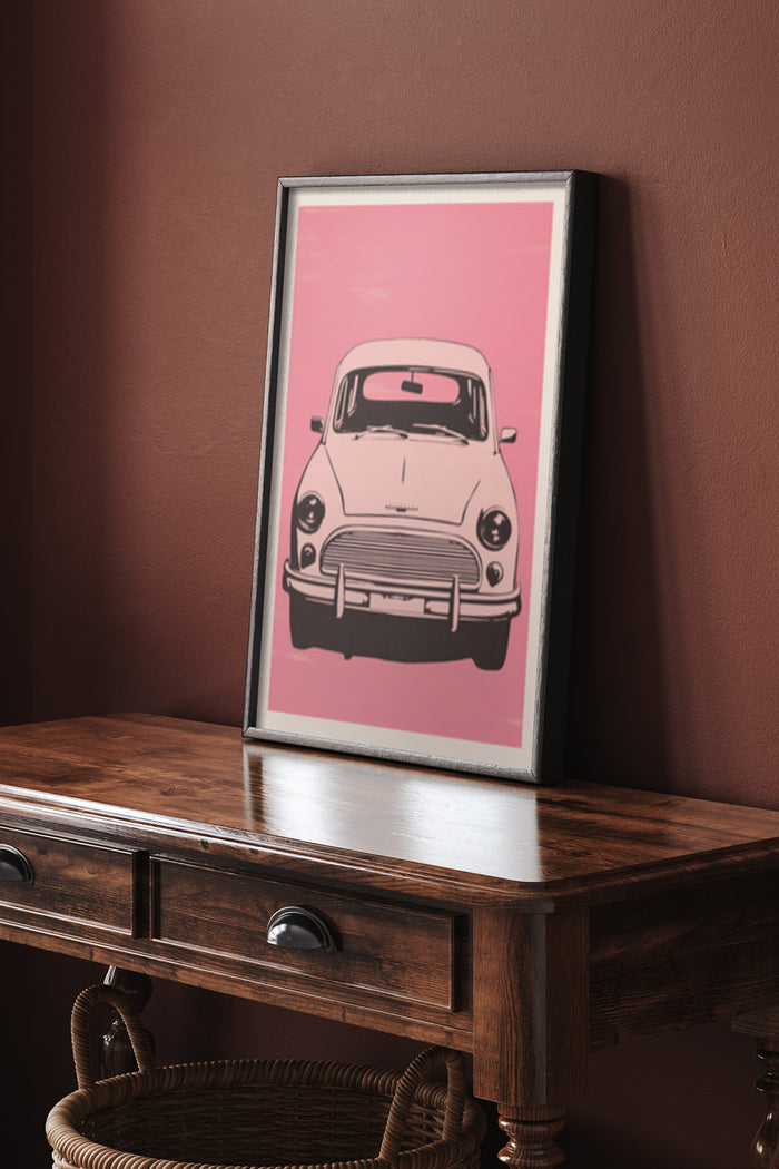 Framed vintage car poster with pink background on wooden side table