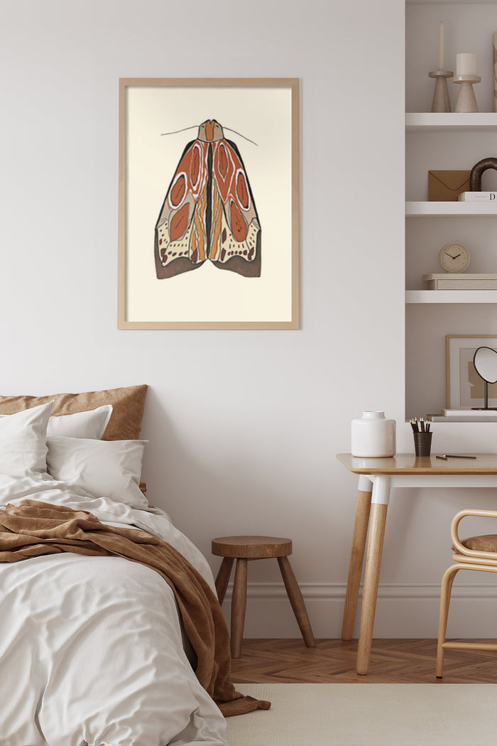 Vintage style moth illustration art poster hanging on bedroom wall above a stylish desk setup