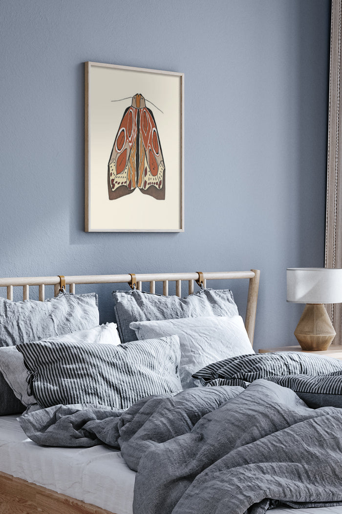 Vintage moth illustration poster framed on a bedroom wall with stylish bedding