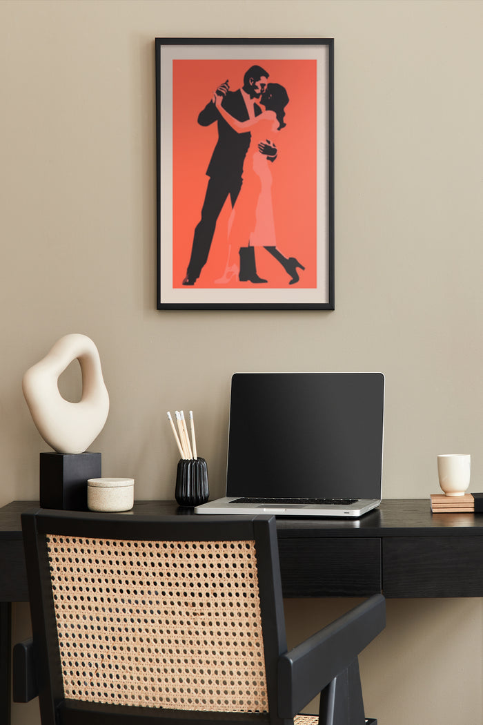 Vintage red and orange dance poster framed on a home office wall, with a laptop on the desk