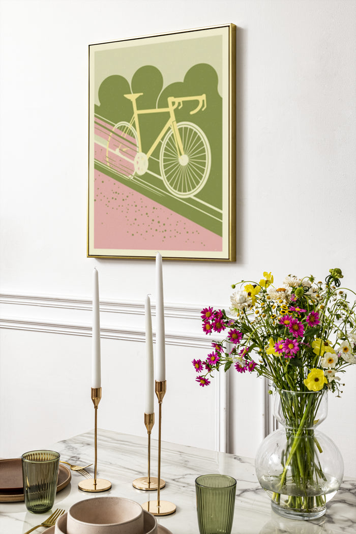 Vintage style green and pink bicycle poster in a gold frame on a white wall above a modern dining room setup with candles and flowers