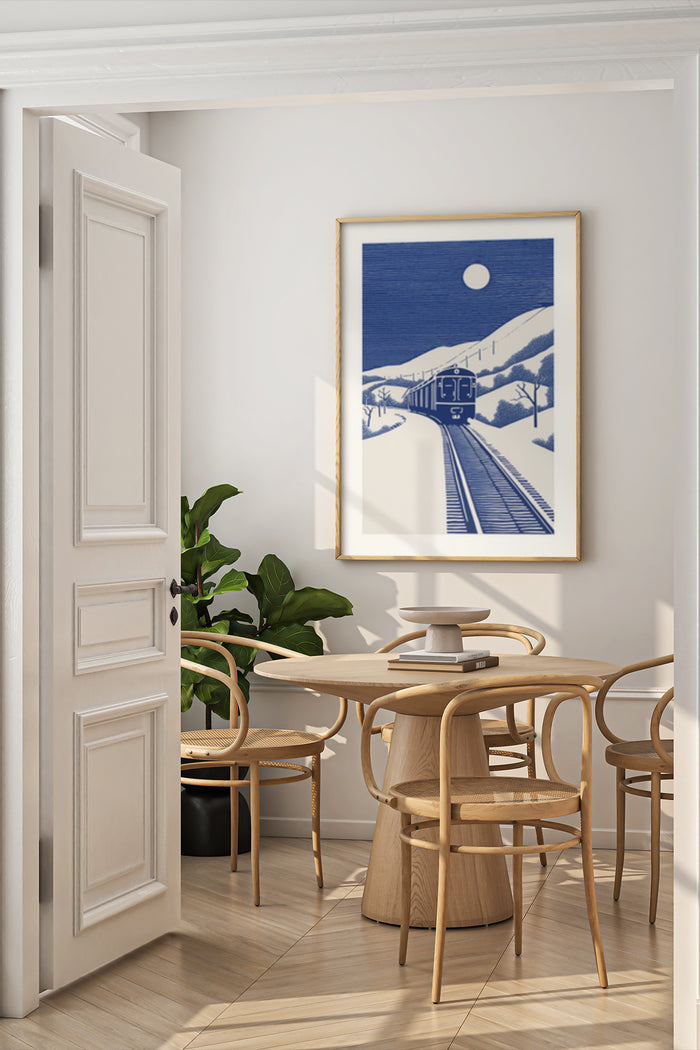 Vintage blue and white train travel poster framed on a minimalist dining room wall beside a wooden table and chairs