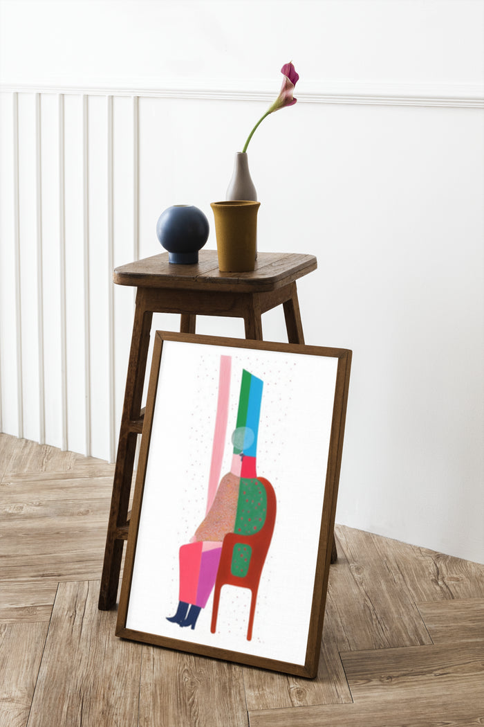 Abstract modern art poster in frame next to ceramic vases on wooden stool against white wall