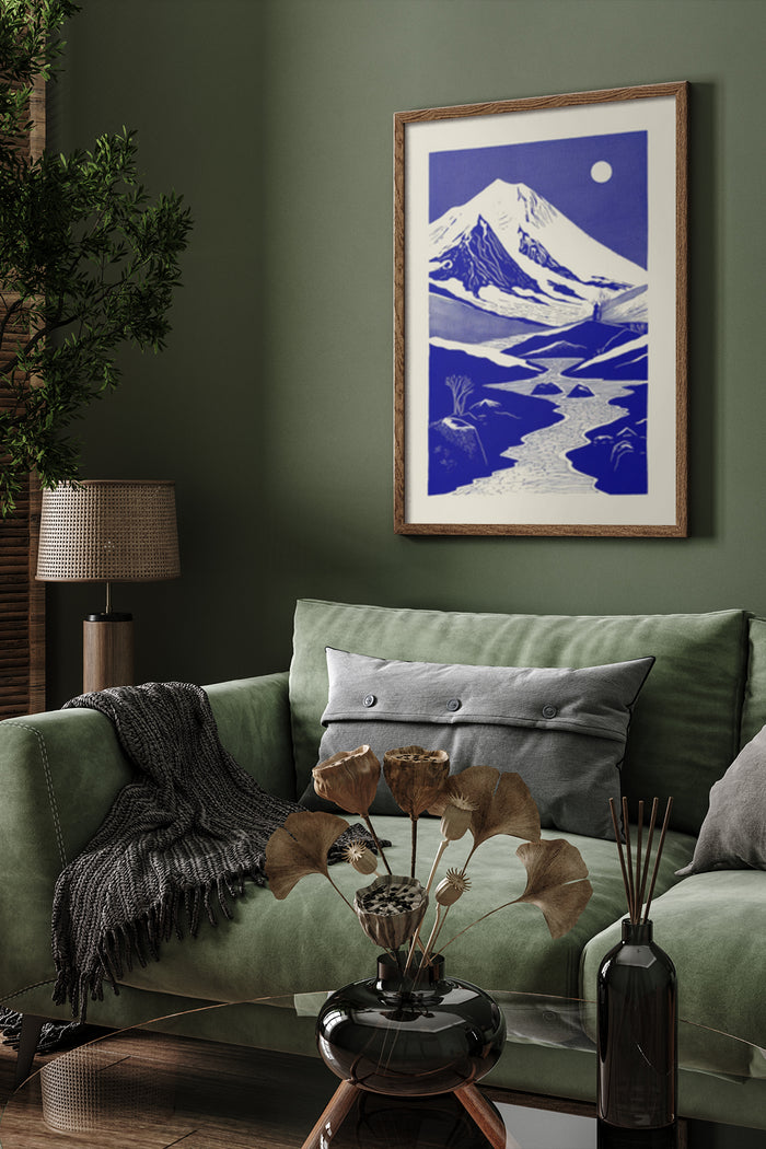 Elegant interior design with a framed blue and white vintage mountain landscape poster above a green velvet sofa