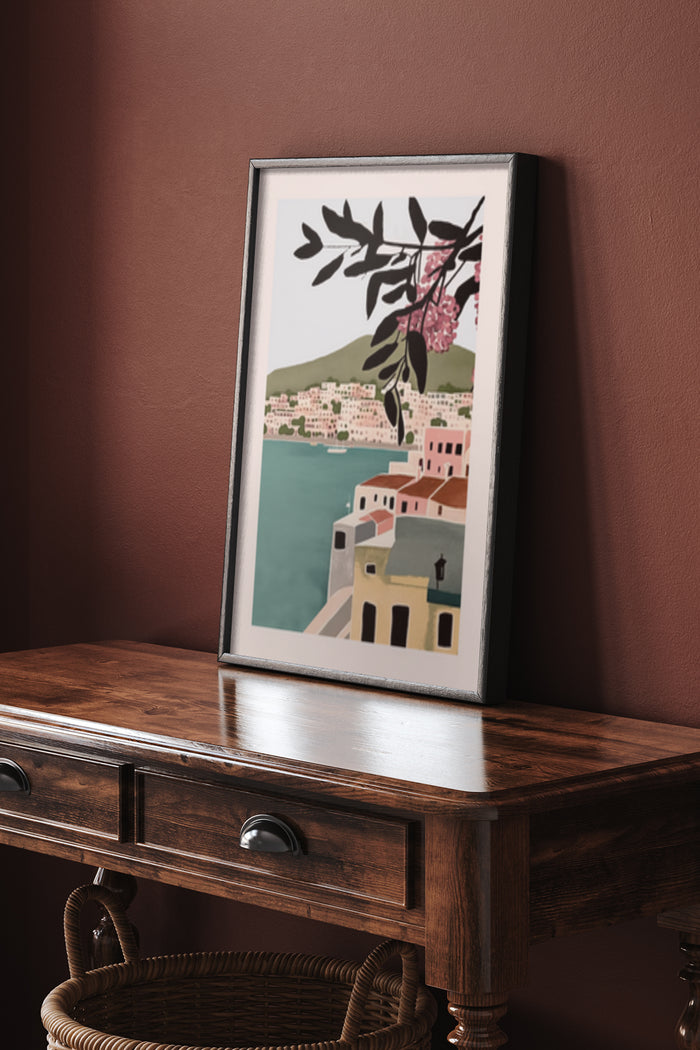 Framed coastal town artwork with flowers overlooking a seaside village displayed in a stylish interior