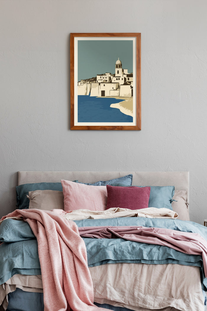 Framed poster of a stylized coastal village hanging above a bed with colorful linens in a modern bedroom decor