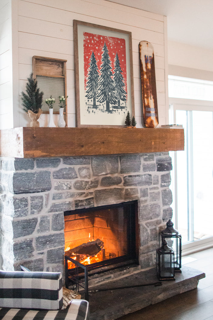 Cozy living room with burning fireplace and holiday-inspired Christmas tree artwork on mantlepiece