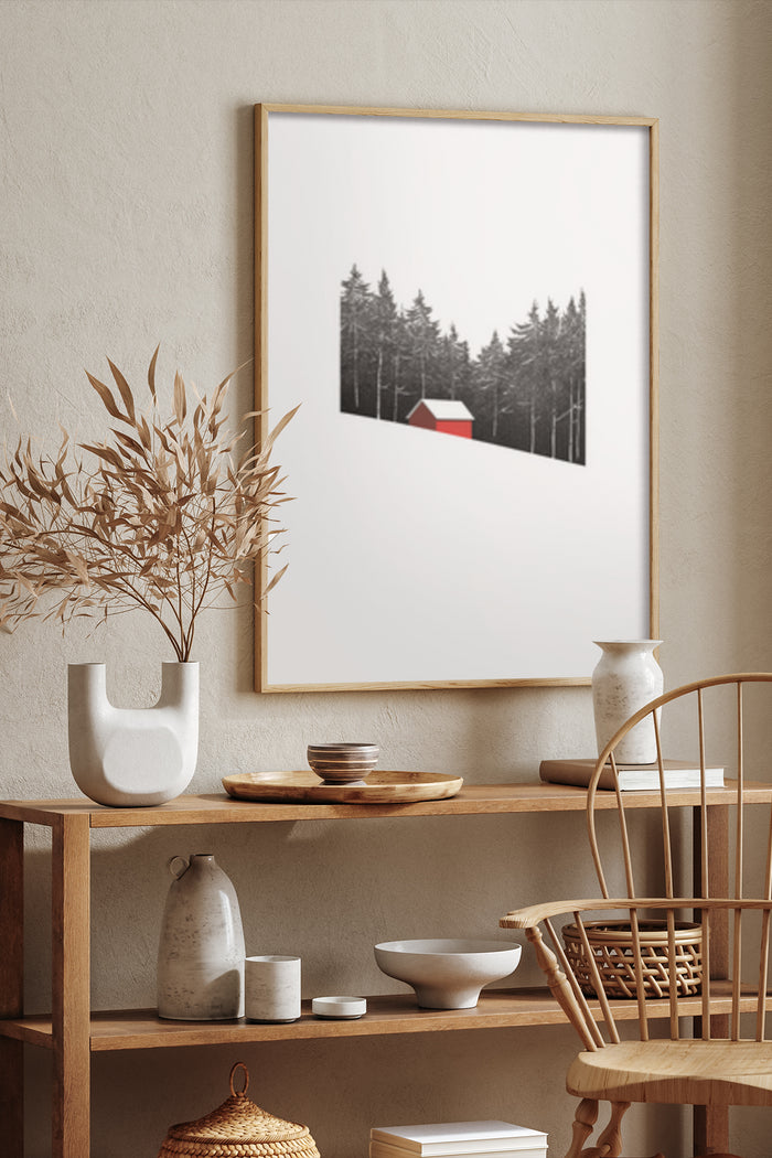 Minimalist black and white artwork of a forest with a red cabin in a poster frame on a textured wall