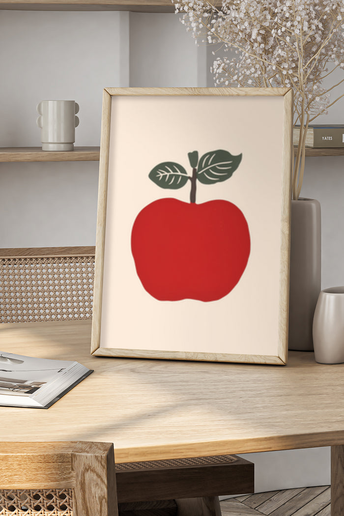Modern minimalist red apple artwork in natural wood frame on home decor shelf