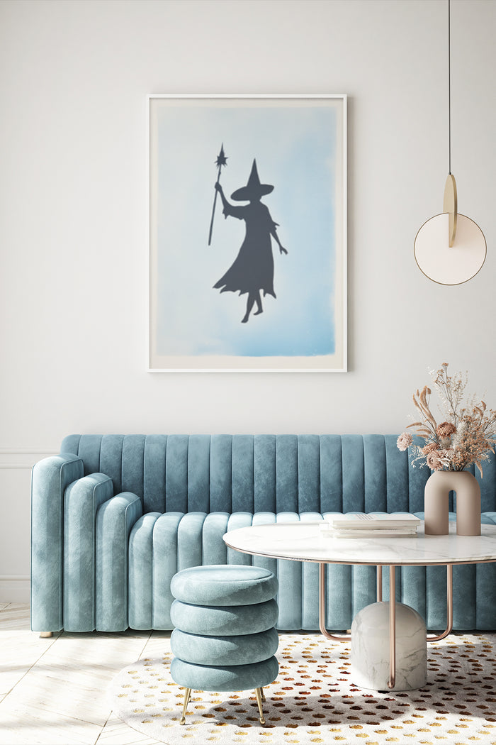 Minimalist witch silhouette poster art displayed above blue sofa in a contemporary interior setting