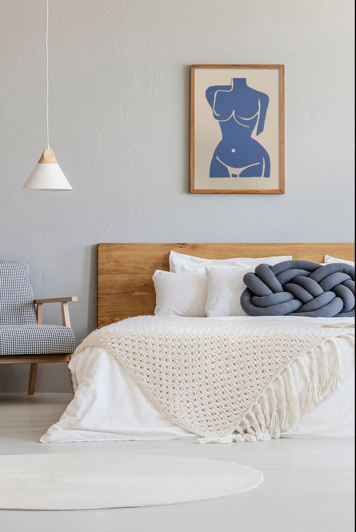 Contemporary bedroom design featuring a bed with white knit throw and an abstract female figure artwork framed on wall