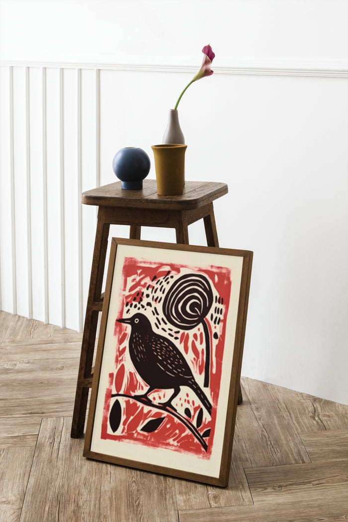 Stylish linocut print poster featuring a bird and snail in red and black on display in a contemporary home setting
