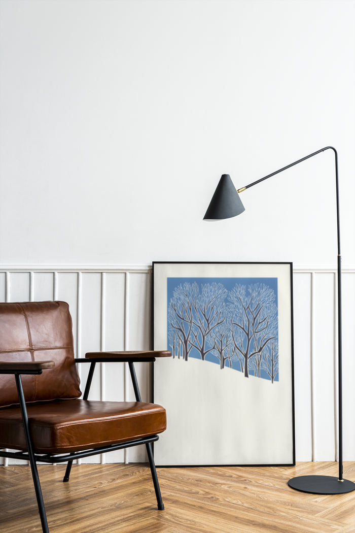 Contemporary blue tree artwork displayed in a stylish living room with brown leather chair and black floor lamp
