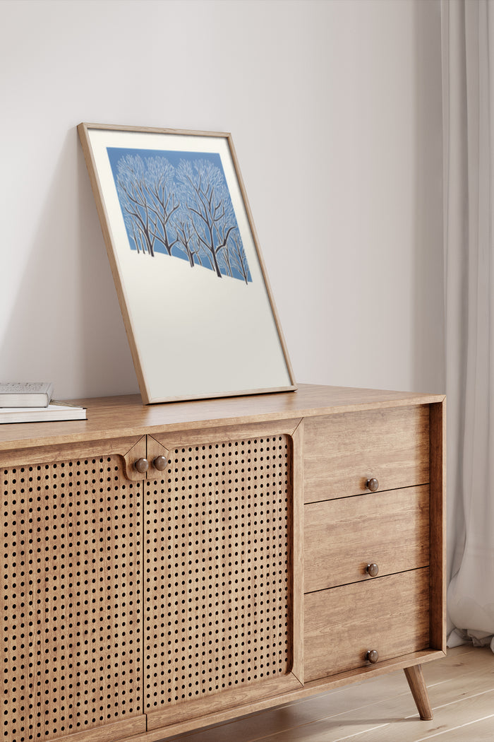 Stylish modern artwork depicting blue trees in a wooden frame on a Scandinavian sideboard interior