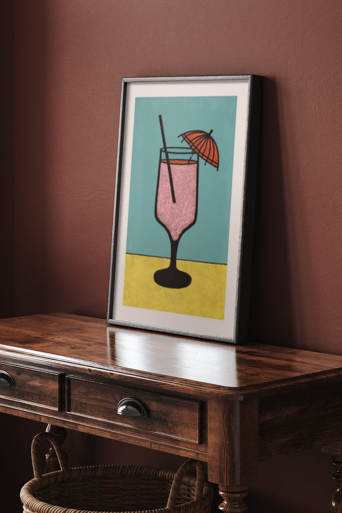 Stylized modern cocktail poster with pink drink and umbrella in a frame on wooden sideboard