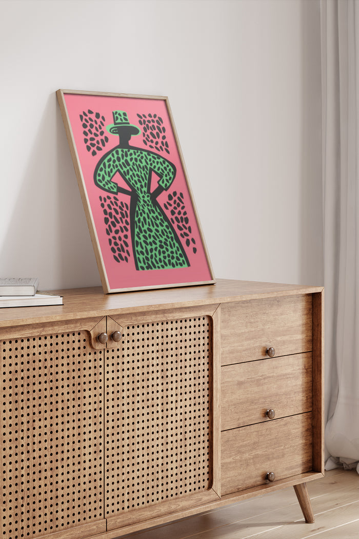 Modern green dress silhouette artwork poster on a pink background displayed in a home setting