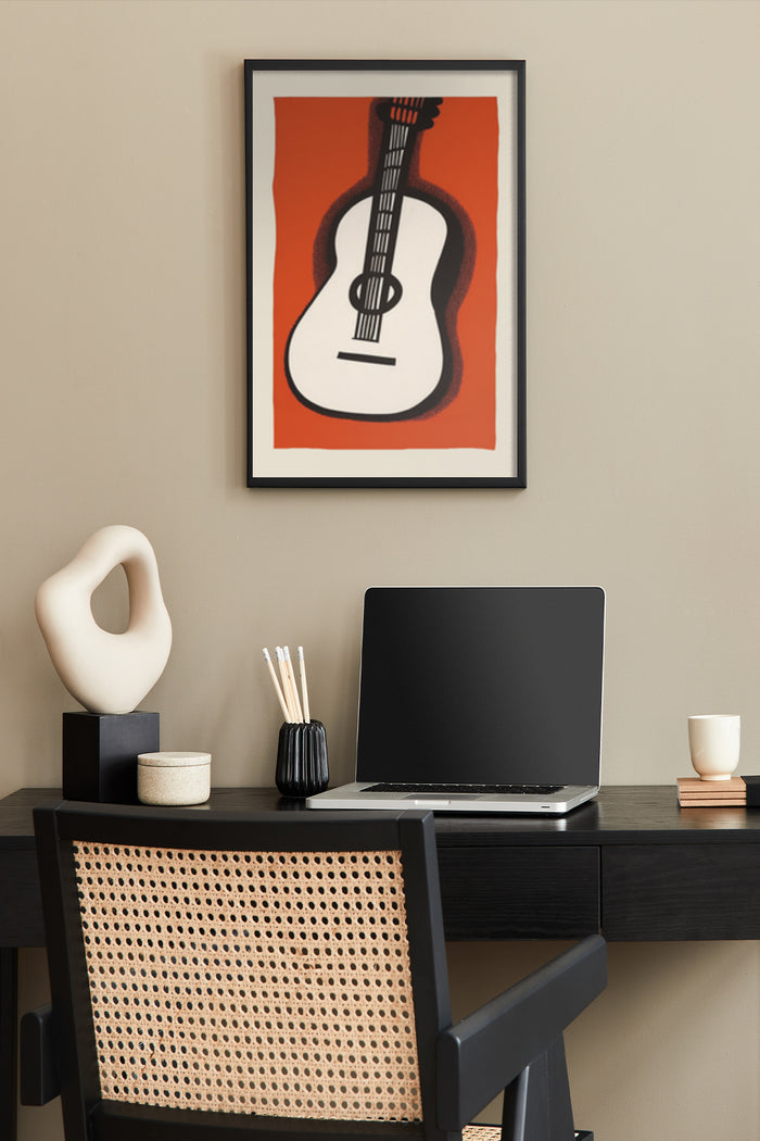 Stylized modern guitar artwork poster in a home office setting above a laptop on desk