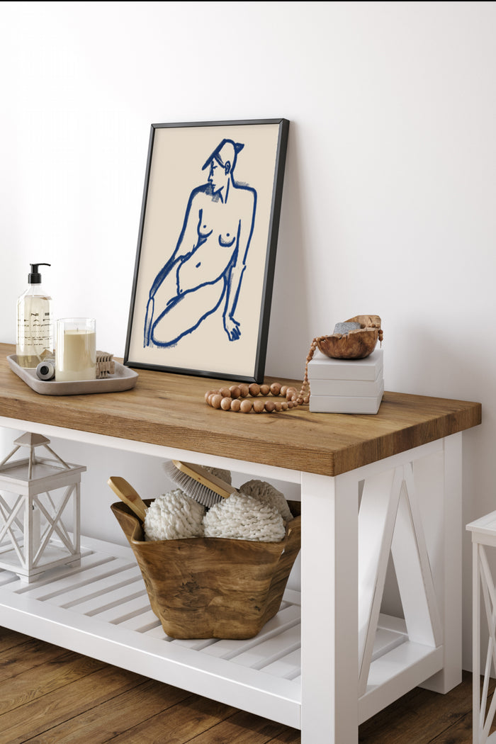 Modern minimalist line drawing of a seated female figure poster displayed on a wooden console table