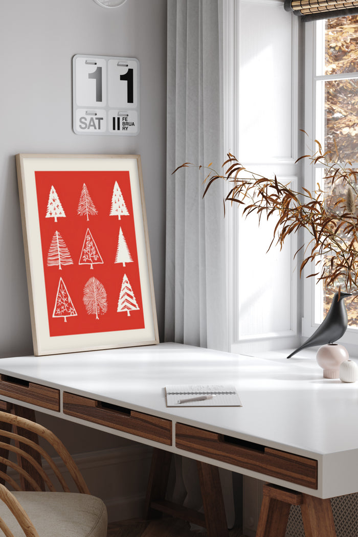 Contemporary red poster with stylized Christmas tree illustrations in a home office setting