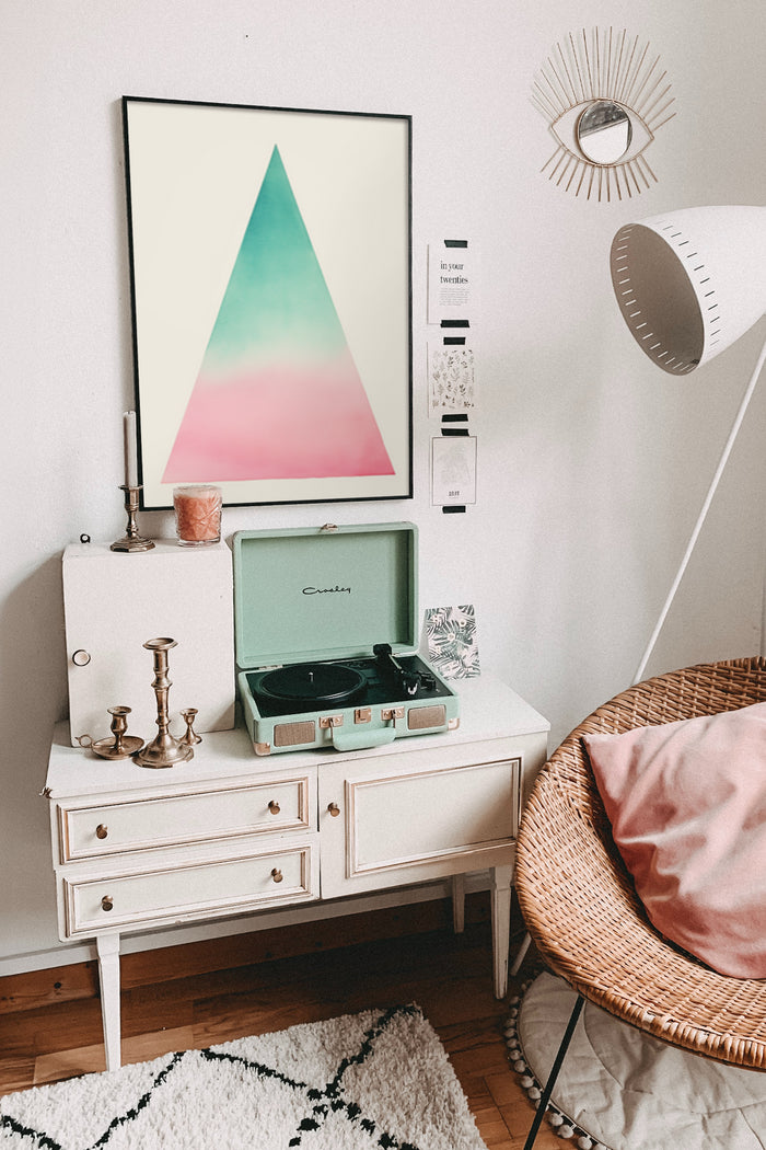 Contemporary triangle gradient poster framed on a white wall within a vintage styled interior with wicker chair