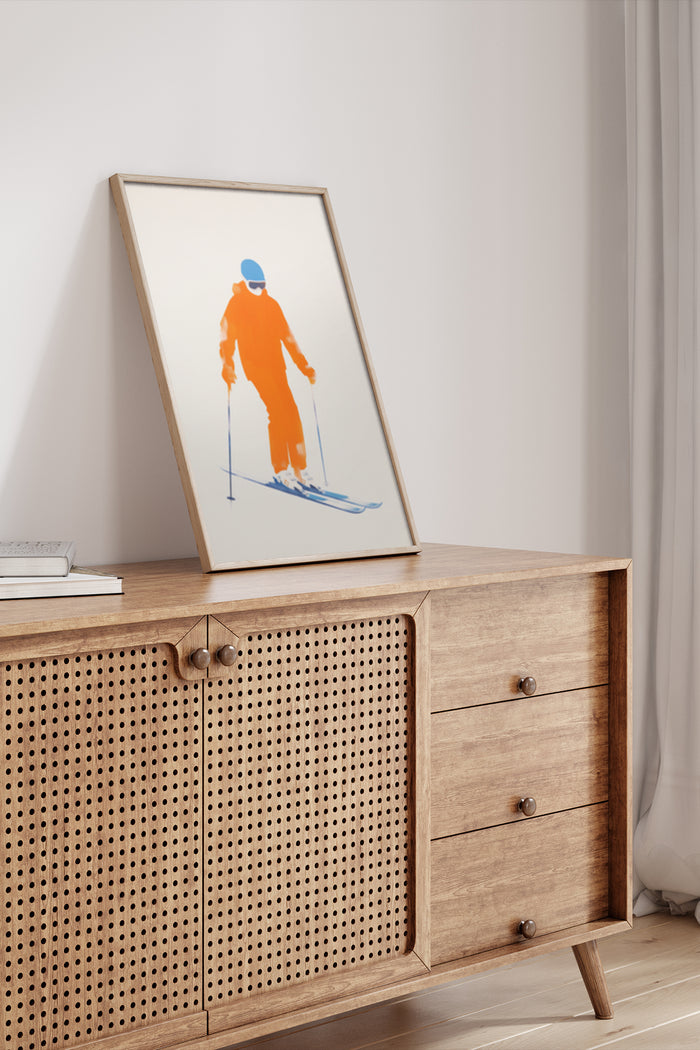 Orange Skier Poster Art in Wooden Frame as Modern Home Decoration on Sideboard