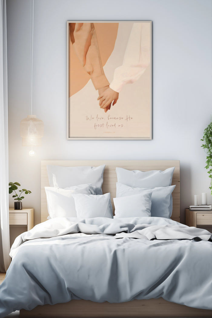 Romantic poster of a couple holding hands with the quote 'We love because He first loved us' hanging in a modern bedroom