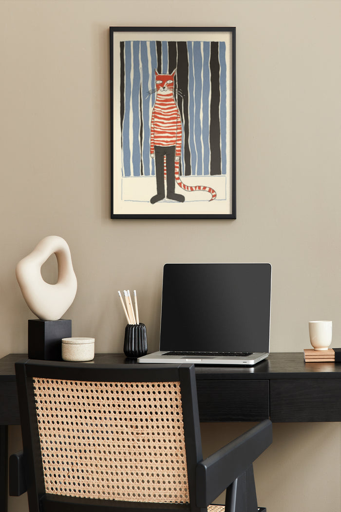 Colorful striped cat illustration poster hanging above a workspace with modern laptop and office supplies