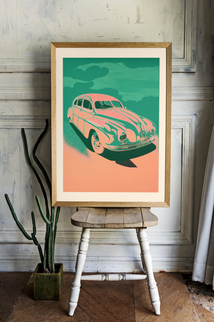 vintage style poster of a classic car displayed in a contemporary room with wooden floor and cactus plant