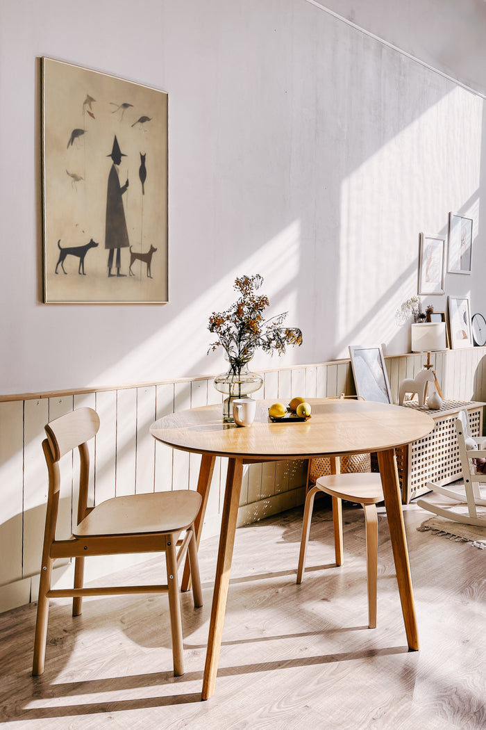 Vintage style poster with a figure and animals on a wall in a bright dining room interior