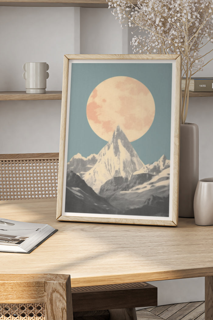 Vintage style mountain landscape poster featuring full moon and snowy peaks in a wooden frame on a table